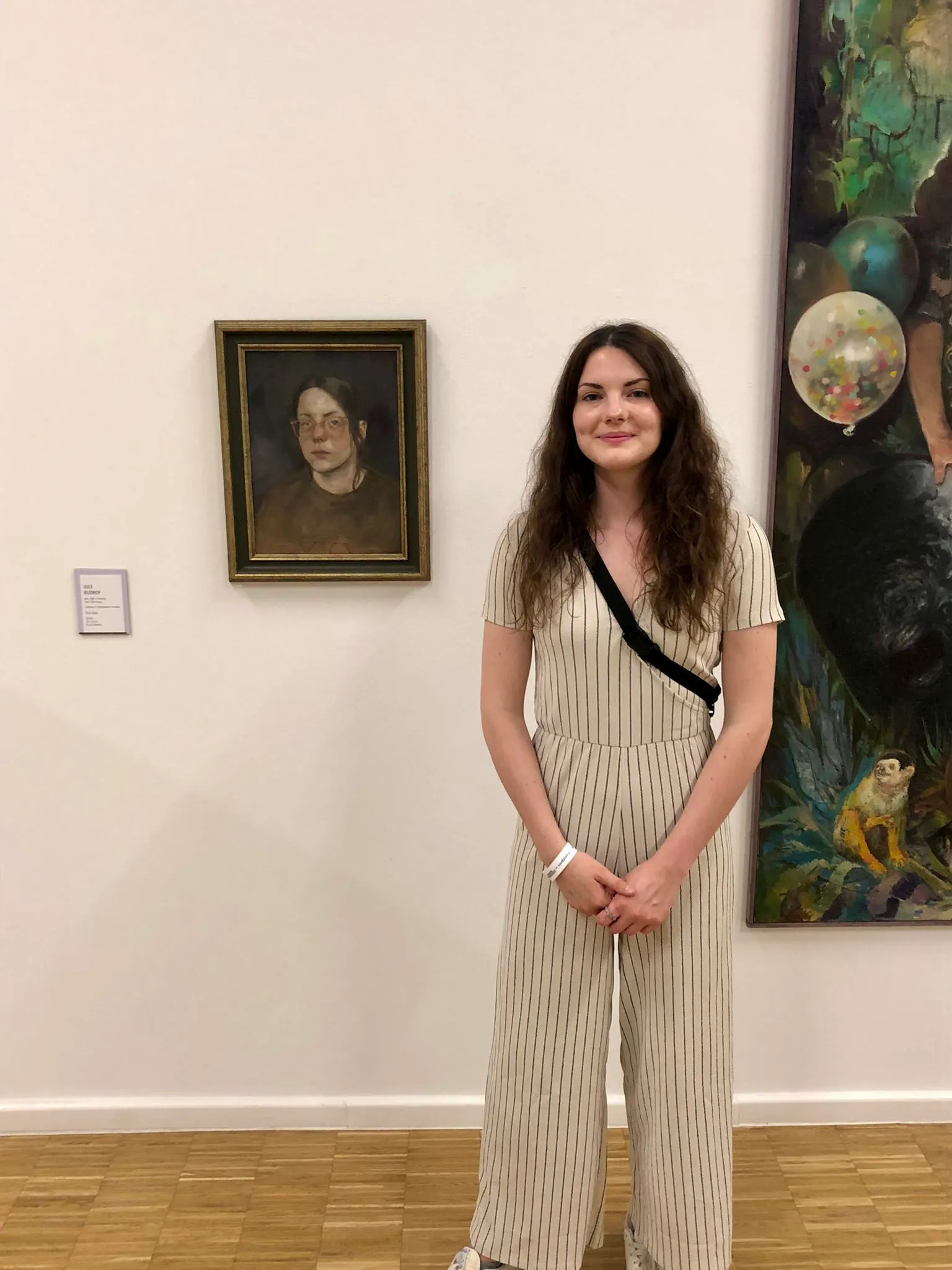 Jule Rudrof vor einem Ölportrait bei der Ausstellung der Nürnberger Nachrichten.